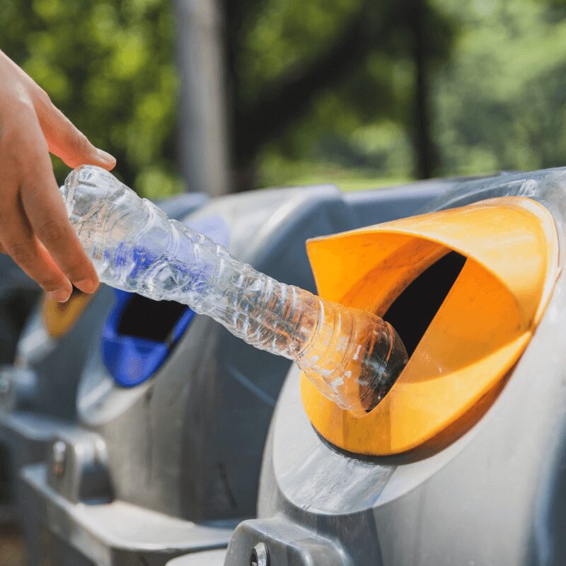 woman recycling plastic in bins